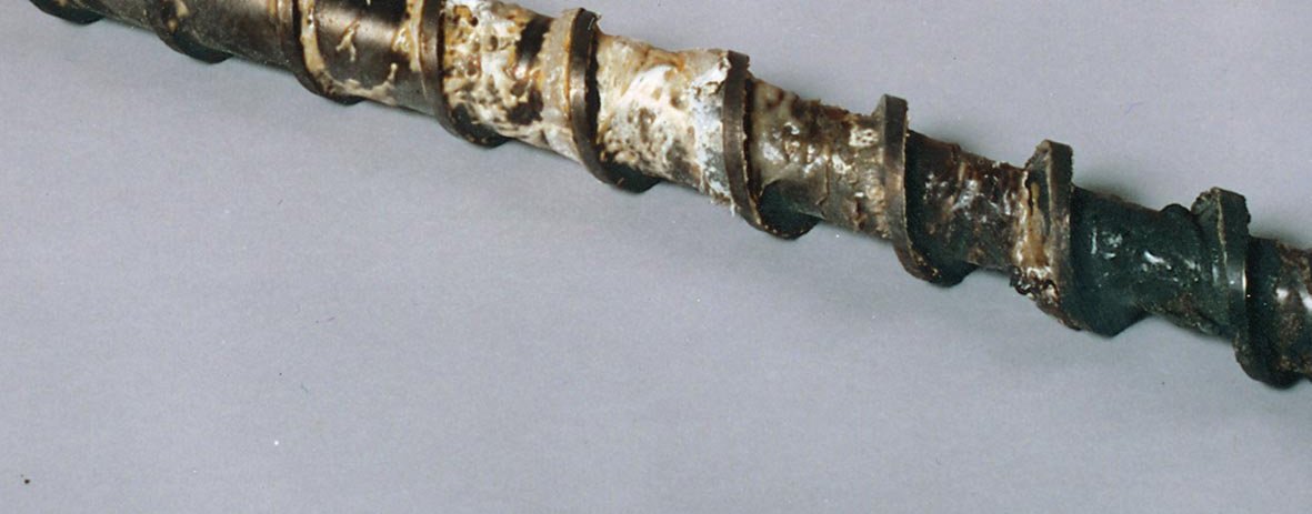 Production feed screw with carbonized polymer buildup before cleaning