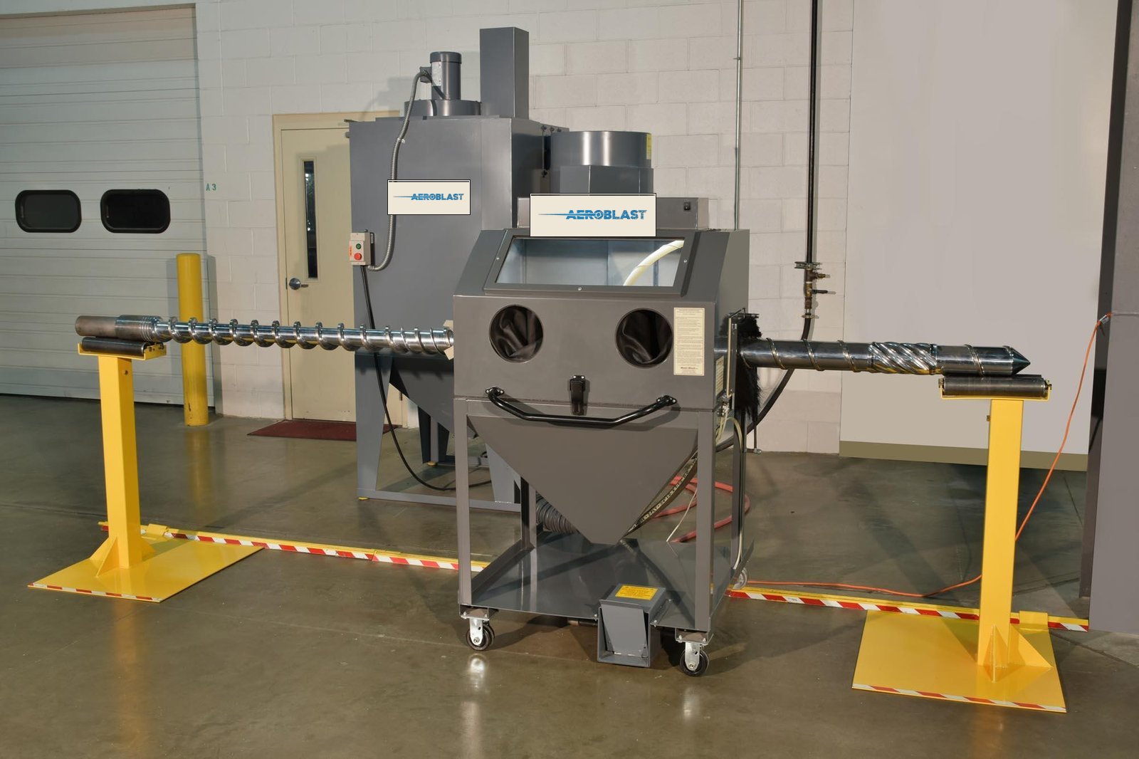 The patented AeroBlast mobile clam-shell cleaning cabinet, with a feed screw loaded on its integrated support stands.